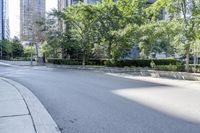 a car driving down an empty street lined with tall buildings and trees in the background