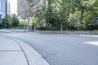 a car driving down an empty street lined with tall buildings and trees in the background