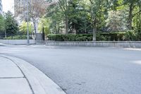 a car driving down an empty street lined with tall buildings and trees in the background