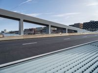 a person is riding a skateboard over a bridge near a cityscape and buildings