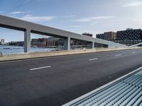 a person is riding a skateboard over a bridge near a cityscape and buildings