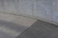 man on skateboard in mid air at the top of a concrete ramp along side the river