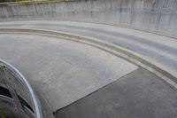 man on skateboard in mid air at the top of a concrete ramp along side the river