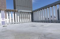 a person is skateboarding on the concrete roof of a building, with tall buildings behind them