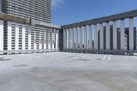 a person is skateboarding on the concrete roof of a building, with tall buildings behind them