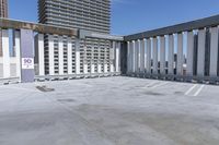 a person is skateboarding on the concrete roof of a building, with tall buildings behind them