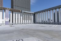 a person is skateboarding on the concrete roof of a building, with tall buildings behind them