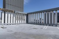 a person is skateboarding on the concrete roof of a building, with tall buildings behind them