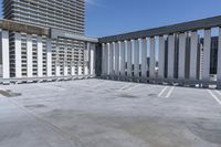 a person is skateboarding on the concrete roof of a building, with tall buildings behind them