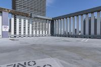 a person is skateboarding on the concrete roof of a building, with tall buildings behind them