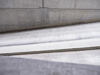 a skateboarder performing tricks on some stairs outside of a building the ramp in front is concrete