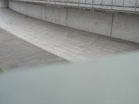 the skateboarder is skateboarding down the concrete walkways near a riverbank