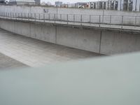 the skateboarder is skateboarding down the concrete walkways near a riverbank