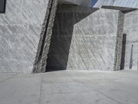 a person skateboarding in front of a wall that is partially made out of concrete