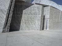 a person skateboarding in front of a wall that is partially made out of concrete