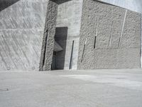 a person skateboarding in front of a wall that is partially made out of concrete