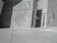 a person skateboarding in front of a wall that is partially made out of concrete