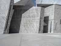 a person skateboarding in front of a wall that is partially made out of concrete