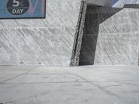 a person skateboarding in front of a wall that is partially made out of concrete