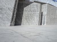 a person skateboarding in front of a wall that is partially made out of concrete