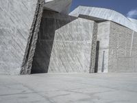 a person skateboarding in front of a wall that is partially made out of concrete