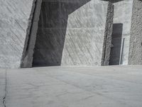 a person skateboarding in front of a wall that is partially made out of concrete