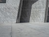 a person skateboarding in front of a wall that is partially made out of concrete