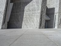 a person skateboarding in front of a wall that is partially made out of concrete