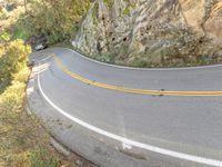 a person skateboarding down a curvy road in the mountains at sunset time