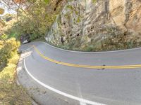 a person skateboarding down a curvy road in the mountains at sunset time