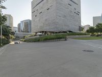 a person on a skateboard in a city square next to the building that is a library