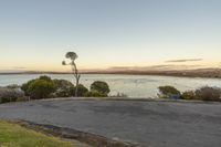 a skateboarder is riding on an empty parking lot overlooking the sea and mountains