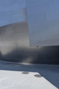 a man riding a skateboard down a road next to tall buildings and a sidewalk