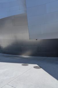 a man riding a skateboard down a road next to tall buildings and a sidewalk