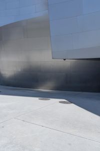 a man riding a skateboard down a road next to tall buildings and a sidewalk