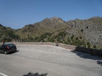 a person riding a skate board next to a hill of rocks with trees in the background