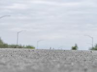 a person skateboarding across an empty open road with trees in the background at the bottom