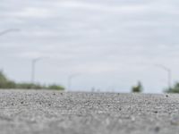 a person skateboarding across an empty open road with trees in the background at the bottom