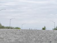 a person skateboarding across an empty open road with trees in the background at the bottom