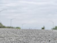 a person skateboarding across an empty open road with trees in the background at the bottom