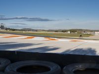 the green road and orange and white stripe line at an event near the racetrack and stadium