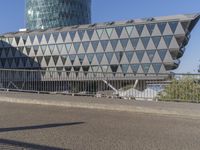 a skateboarder skates across an empty bridge with buildings on both sides in the background