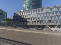 a skateboarder skates across an empty bridge with buildings on both sides in the background
