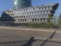 a skateboarder skates across an empty bridge with buildings on both sides in the background