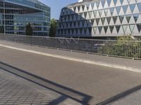 a skateboarder skates across an empty bridge with buildings on both sides in the background