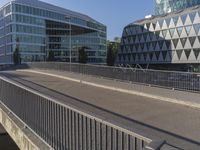 a skateboarder skates across an empty bridge with buildings on both sides in the background