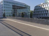 a skateboarder skates across an empty bridge with buildings on both sides in the background