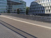 a skateboarder skates across an empty bridge with buildings on both sides in the background