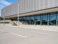 the man skateboards in front of an empty parking lot by a glass - clad building