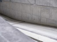 a man riding a skateboard on the side of a concrete wall's edge